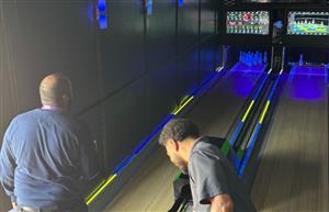 two adults bolwing
